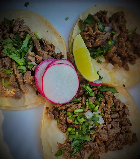 Asada street tacos on corn tortillas with cilantro, onion, radish and lime